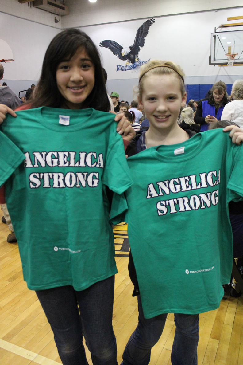 Ruby Holschen, left, and Mya Houglin display T-shirts supporting their friend Angelica Haakenson, 11, of Anchor Point who was injured in a Christmas Day wreck on the Sterling Highway.-Photo by McKibben Jackinsky, Homer News