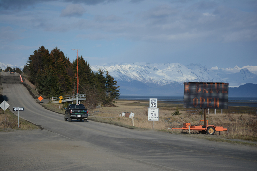 A truck heads east on Kachemak Drive from the Homer Spit Road about 6:30 p.m. Tuesday. The road reopened that night after workers repaired a mudslide that happened April 19. The mudslide pushed a clump of spruce trees into Mud Bay, seen at right in the photo.-Photo by Michael Armstrong, Homer News