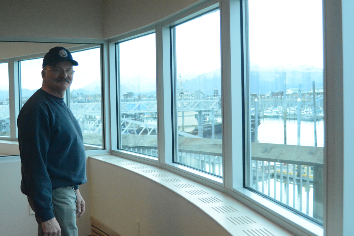 Harbormaster Bryan Hawkins stands by one of the windows overlooking the harbor in the new Harbormaster’s Office building.-Photo by Michael Armstrong, Homer News