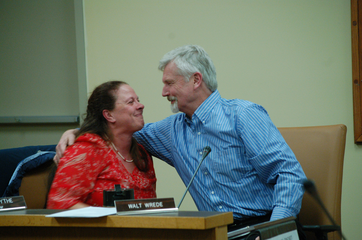 Homer City Manager Walt Wrede, right, gives Homer Mayor Beth Wythe a hug after she finishes making comments about his 12 years of service during Monday’s city council meeting. Wrede’s last day on the job is Dec. 31.-Photo by Michael Armstrong, Homer News