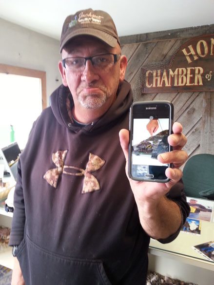 Unhappy angler Bill Brock of Anchor Point shows off a photo of the tagged halibut he caught Sunday. Reason for his frown: Brock didn’t have a derby ticket. -Photo provided