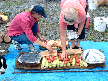 Toni Adams of Sterling and Patti Boiley of Homer prepare food for the fire at Homer Yacht Club’s 2005 clam bake at Tutka Bay.-Photos by McKibben Jackinsky, Homer News
