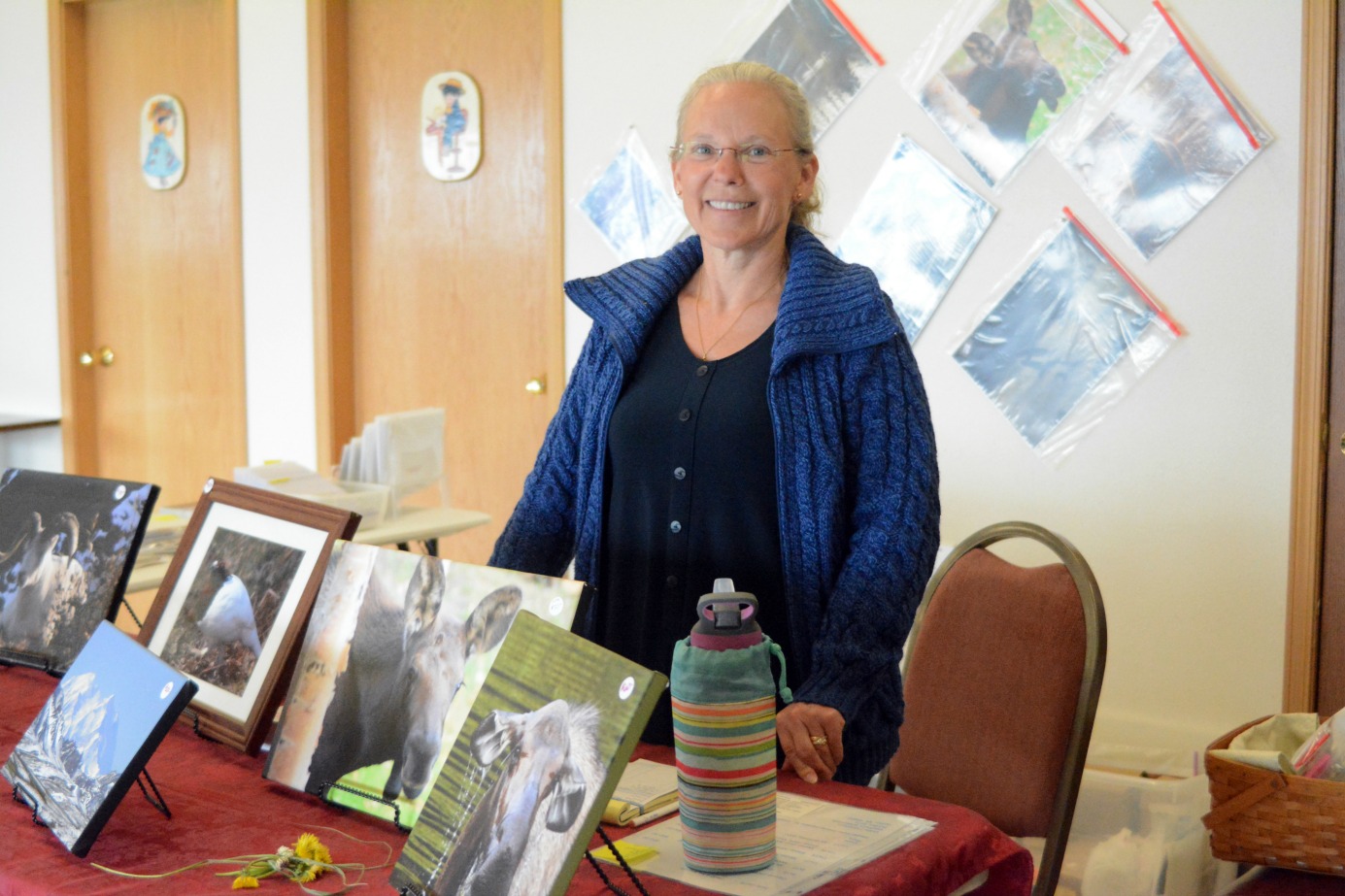 hotographer Vicki Swenson stands at her booth at the Swan Market on Tuesday. Set up for cruise ship days this summer, the market is open 10 a.m.-3 p.m. at the Homer Elks Lodge when the Maasdam is in port. For renting booths or more information, contact Adulai Salam, owner and manager, at 299-4576 or email theswanmarket@gmail.com.-Photo by Michael Armstrong, Homer News