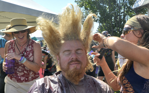 Jerami Youngblood of Homer gets his hair teased by Allyson Novy of Anchorage as part of the festival fun.-Photo by Rashah McChesney, Morris News Service - Alaska