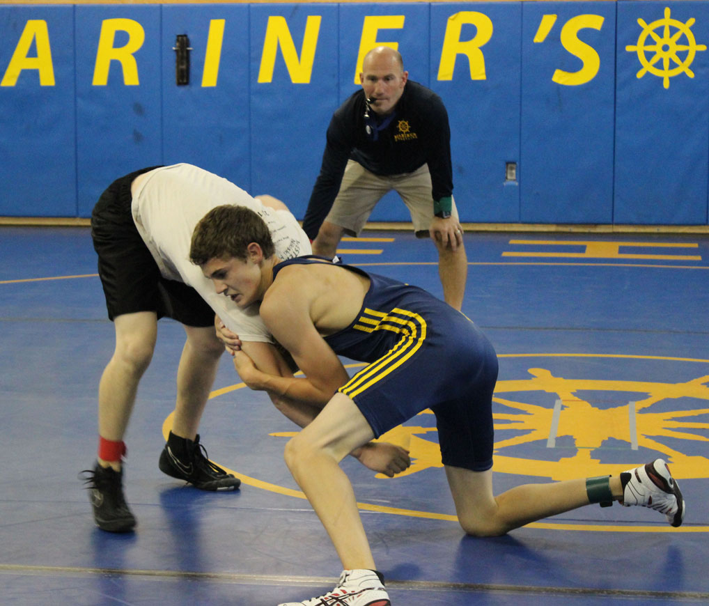 Mariner Jared Brant, who placed fifth at state last year, wrestles his Nikiski opponent during scrimmages in the Mariner mat room on Saturday. Mariner Coach Chris Perk referees.-Photo by McKibben Jackinsky, Homer News
