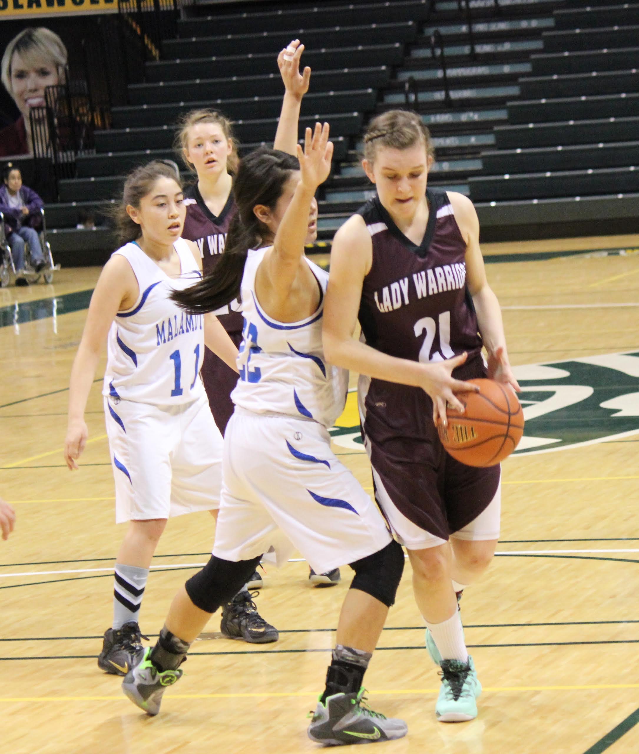 Nikolaevsk's Serafima Kalugin works around the Newhalen defense in the battle for fourth-place in the 1A State basketball tournament.-Photo by McKibben Jackinsky, Homer News