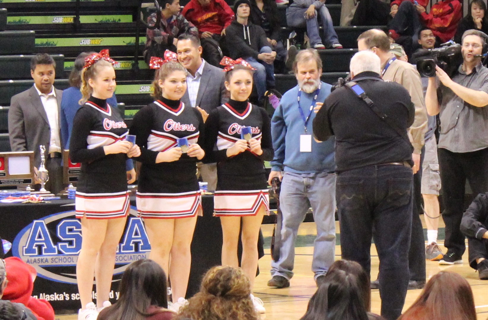 The Seldovia Sea Otter cheerleaders are recognized for their energetic support of their during the award ceremony at the ASAA 1A State Basketball Tournament. From left: Lisa Neumann, Violet Mitchell, Ariana Waterbury. -Photo by McKibben Jackinsky, Homer News