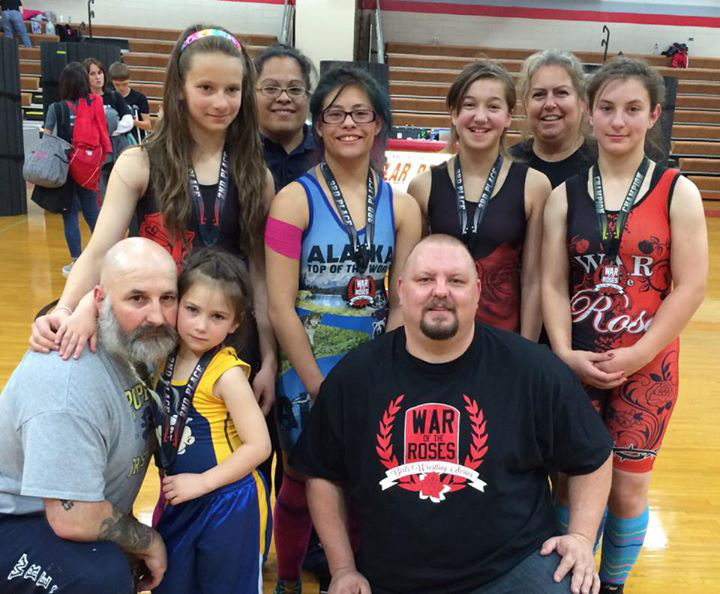 Alaska wrestlers, coaches and event organizer pose for a group photos. Back row from left: Alison Wells, Coach Janie Martin, Jadzia Martin, Mina Cavazos, Mikki Wells, McKenzie Cook. Front Row from left: Todd Cook, Saoirse Cook and Brent Harvey, War of the Roses organizer.-Photo provided