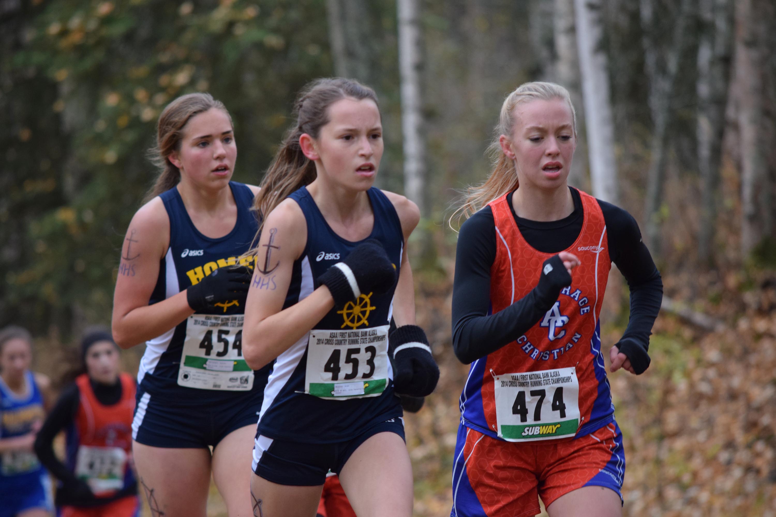 Finish times of Mariners Aurora Waclawski, 454, Alex Hosley, 453, running next to ACS’s Elizabeth Balsan, 474, help secure Homer’s girls varsity cross-country team state championship in Anchorage on Oct. 4. -Photo by Jim Wolfe