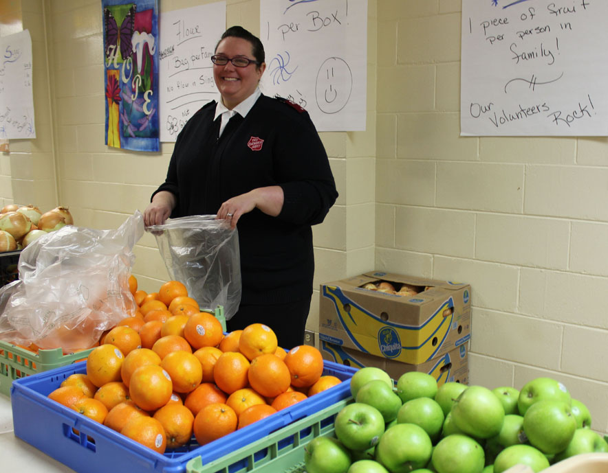 Lt. Christin Frankhauser of the Salvation Army bags fresh vegetables and fruits to be added to the Thanksgiving baskets.