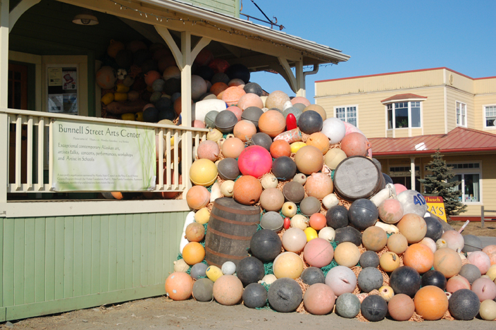 At right, the sculpture flows out of the gallery and fills up part of the porch at Bunnell Street Arts Center. Charzewski guided the art project, using loaned buoys from local fishermen. “Consumption and consumerism is pretty much what I’m conscious of,” he said of his approach to art.-Photo by Michael Armstrong; Homer News