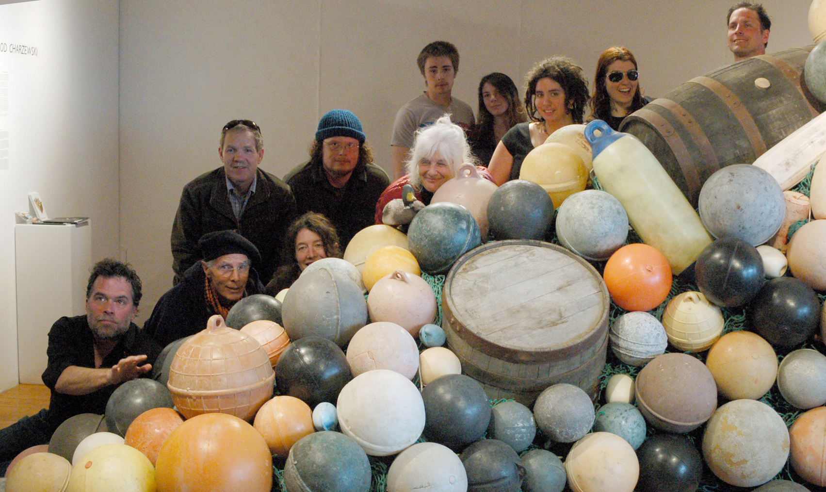 Old Town Artist in Residence Jarod Charzewski, upper right, poses with some of the people who helped create “Buoys and Barrels,” a community art project, last Friday at Bunnell Street Arts Center. From left to right are Michael Walsh, Peter Kauffman, Carl Bice, Asia Freeman, Jeremy Baugh , Wendy Erd, Darien Loftiem, Samantha Inman,  Desiree Hagen, Sarah Frary and Charzewski.-Photo by Michael Armstrong; Homer News