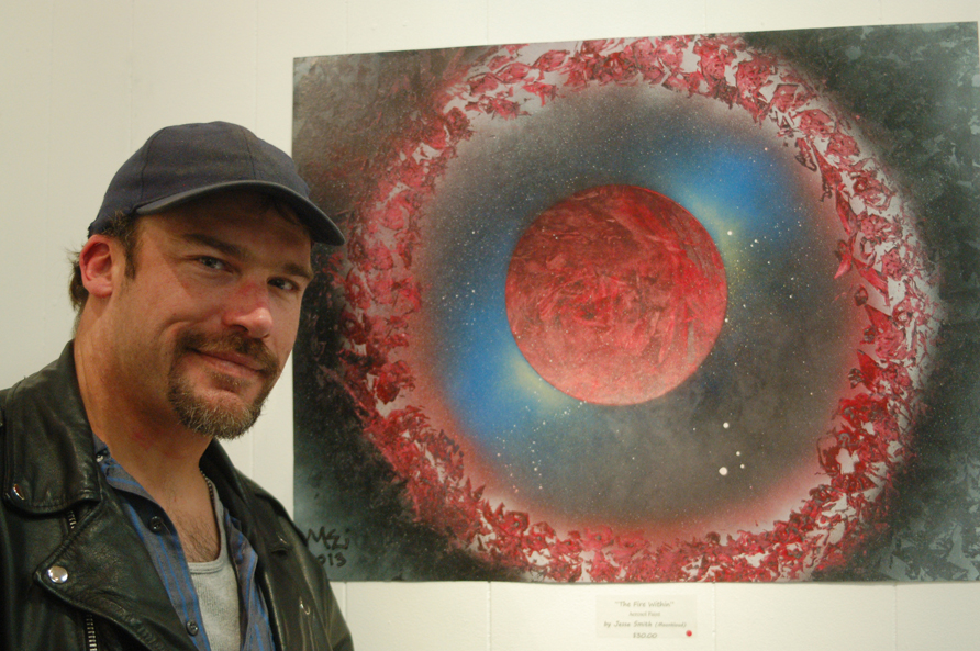 Jesse Smith, Moonkloud, stands next to his painting, “The Fire Within,” at the Emerging Artists show on First Friday for the Homer Council on the Arts.-Photo by Michael Armstrong, Homer News