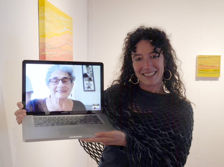 Asia Freeman holds up a laptop computer showing her mother, Karla Freeman, attending by Skype the opening of Karla Freeman’s show earlier this month at Bunnell Street Arts Center.             -Photo by Michael Armstrong, Homer News