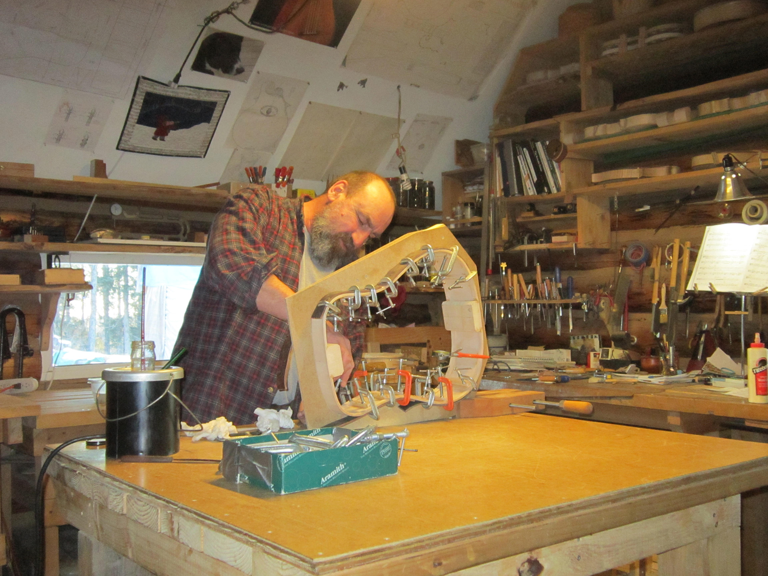 Ray DeMeo glues struts on the frame of a guitar at his Anchor Point home and workshop.-Sarah Richardson