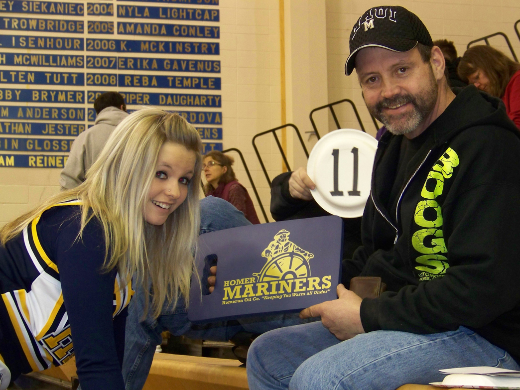 Breeanna Torsen of the Mariner cheer squad finds an easy fundraising target at the Dec. 12 “Meet the Mariners” night, benefiting the Mariner boys basketball team: her dad, Brant “Boog” Torsen.-McKibben Jackinsky