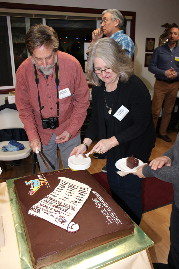 Homer News reporters Michael Armstrong, left, and McKibben Jackinsky, right, cut the cake at the 50th anniversary party for the Homer News last Thursday at VBS / Specialty Stoves. Former reporter Hal Spence is the background. For more photos, see the Spotted page at homernews.com.-Photo by Meldonna Cody