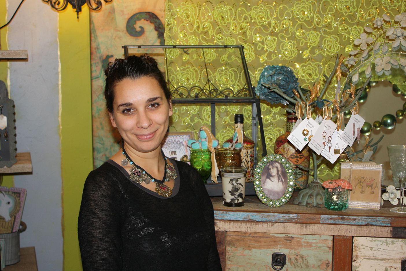 Bekah Dalke pauses for a picture in front of a display that shows a bit of the diversity featured in her new shop, Oodalolly.-Photo by Lindsay Olsen