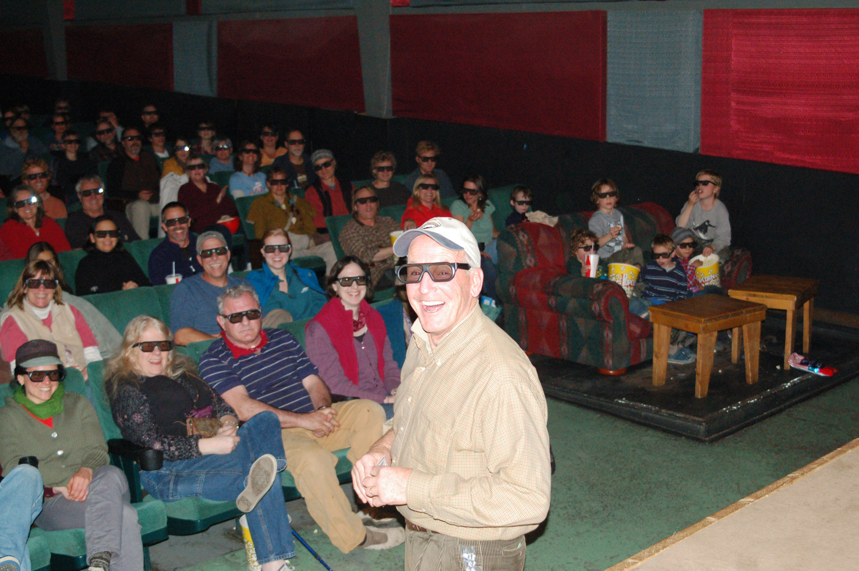 At the eighth annual Homer Documentary Film Festival in 2011, Homer Theatre owner Jamie Sutton, wearing special glasses, introduces Werner Herzog’s “Cave of Forgotten Dreams,” the first digital 3-D film shown at the theater. A digital movie projection system that allowed for the showing of 3-D films was among the improvements Jamie and Lynette Sutton made to the theater. A less high-tech improvement was adding several couches in the theater, seen at right in the photo.-Photo by Michael Armstrong, Homer News