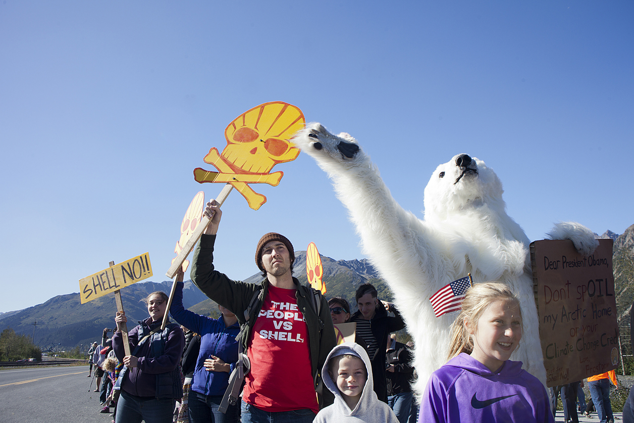Steve Jones, dressed as “Frost Paw” the polar bear, waves to President Barack Obama’s motorcade as it heads toward Exit Glacier on Tuesday in Seward. Jones, a representative from the Center for Biological Diversity, gathered with a crowd of activists along the Seward Highway waving signs to encourage the President to take action on climate change. While environmentalists praise the president for curbing greenhouse gases, they pillory him for granting Shell permission to drill in the Chukchi Sea for the first time in 24 years. On Tuesday, the president of Shell Oil Co. said he expects more protests.-Photo by Rashah McChesney, Morris News Service - Alaska