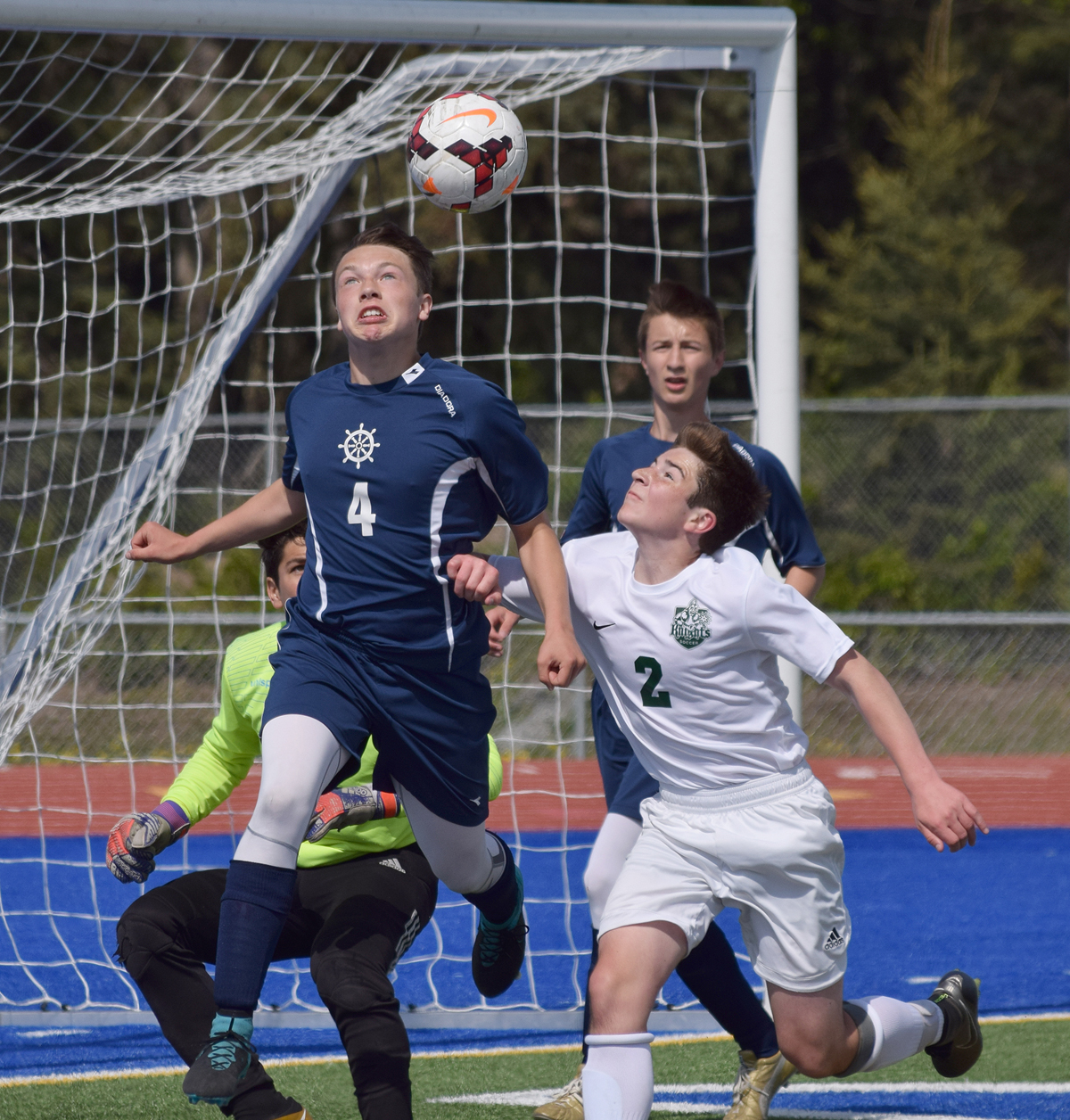 Homer defender Timothy Blakely (4) makes a saving header on a corner kick over Colony midfielder Kyle Dearborn (2) Thursday afternoon in a Northern Lights Conference tournament quarterfinal match at Justin Maile Field in Soldotna.-Photo by Joey Klecka/Peninsula Clarion