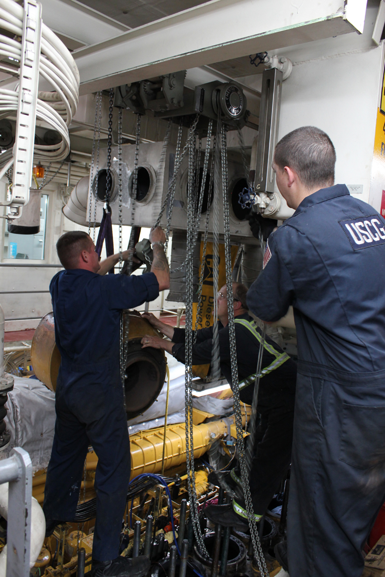 At right, Petty Officer 1st Class Kevin Biggs and Petty Officer 2nd Class Chris Moe remove worn engine parts aboard the U.S. Coast Guard Cutter Hickory in Homer. Biggs and Moe are both machinery technicians who worked on the cutter’s top-end overhaul to prepare for the aids-to-navigation season.-Photo provided