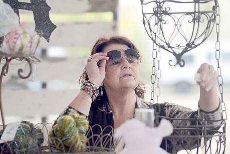 Margo Bouchard checks the price of a hanging basket at the new Swank Street Antiques & Art Market Saturday July 19, 2014 in Soldotna, Alaska. -Photo by Rashah McChesney/Peninsula Clarion