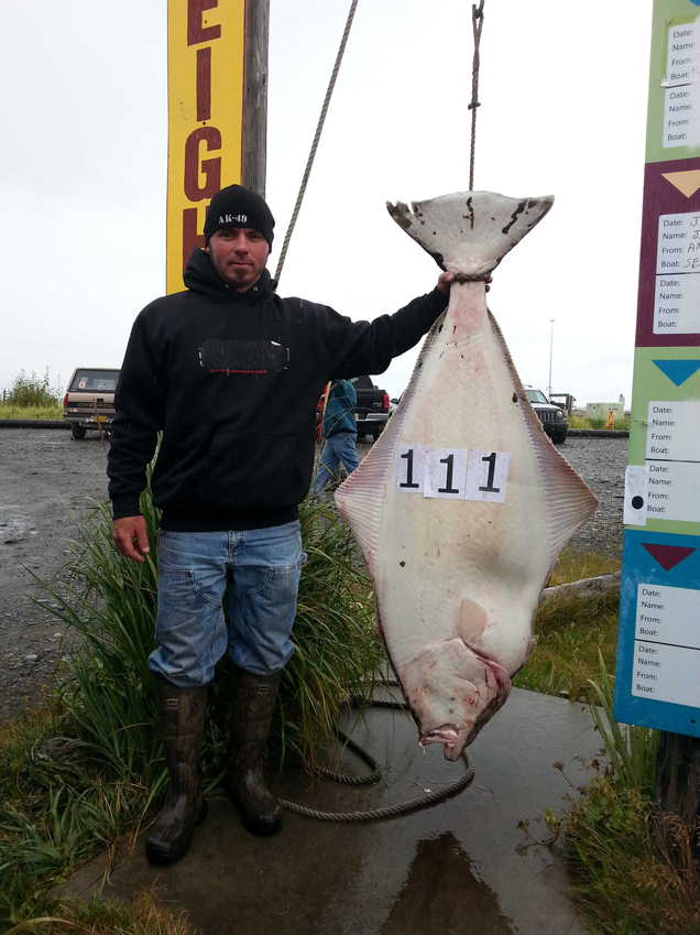 Jason Mecham shows off the 111.80-pound halibut he caught, also on Aug. 3.-Photo provided
