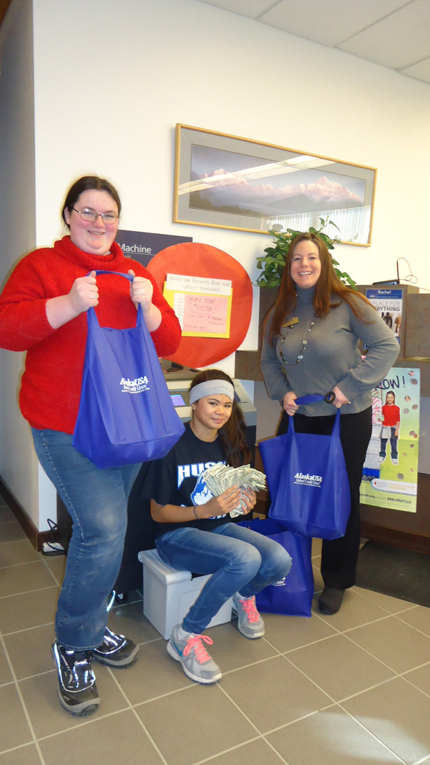 Displaying the results of Homer Middle School’s Pennies for Patients fund drive are HMS students Hannah Mershon and Gabrielle Gregory with Alaska USA Federal Credit Union Manager Alita Mahan.-Photo provided