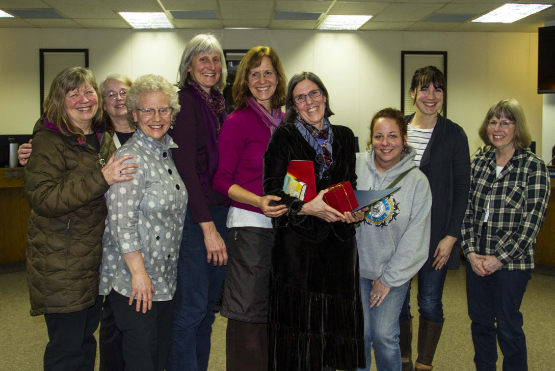 West Homer Elementary School librarian Lisa Whip, recipient of the Kenai Peninsula Borough School Board’s Golden Apple Award, is surrounded by co-workers at Monday’s school board meeting in Soldotna. From left: Pat Moreth, Karen Murdock, Lyn Maslow, Lynn Temple, Judy Gonzalves, Whip, Shele Worsfold, Katie Bynagle and Barb Veeck.-Photo by Pegge Erkeneff