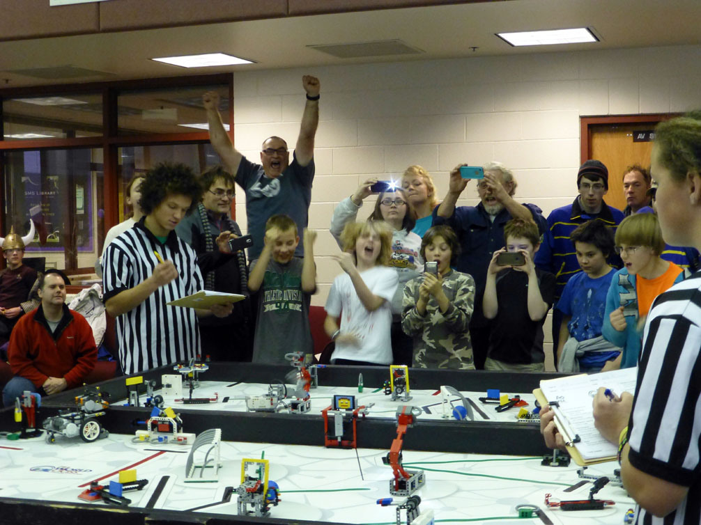 Celebrating completion of a difficult mission at Saturday’s First Lego League regional competition at Skyview Middle School are West Homer Elementary School students, coaches and supporters including, from left, Gary Syth, Coach Jeff Coble, Sam Larson, Coach Bob Romanko, Peter Syth, Alex Franklin, Michelle Geagel, Keri Syth, volunteer Dick Dunn, Eric Marshall, Dakota Moonin, Tadhg Scholz, Principal Ray Marshall and Larry Dunn.