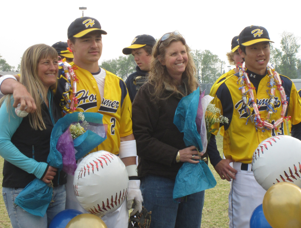 Seniors Tommy Bowe, second to left, with Beth Bowe, and Nahoa Jette, right, with Sue Landreth, are honored at the Mariners’ at-home game on May 21.