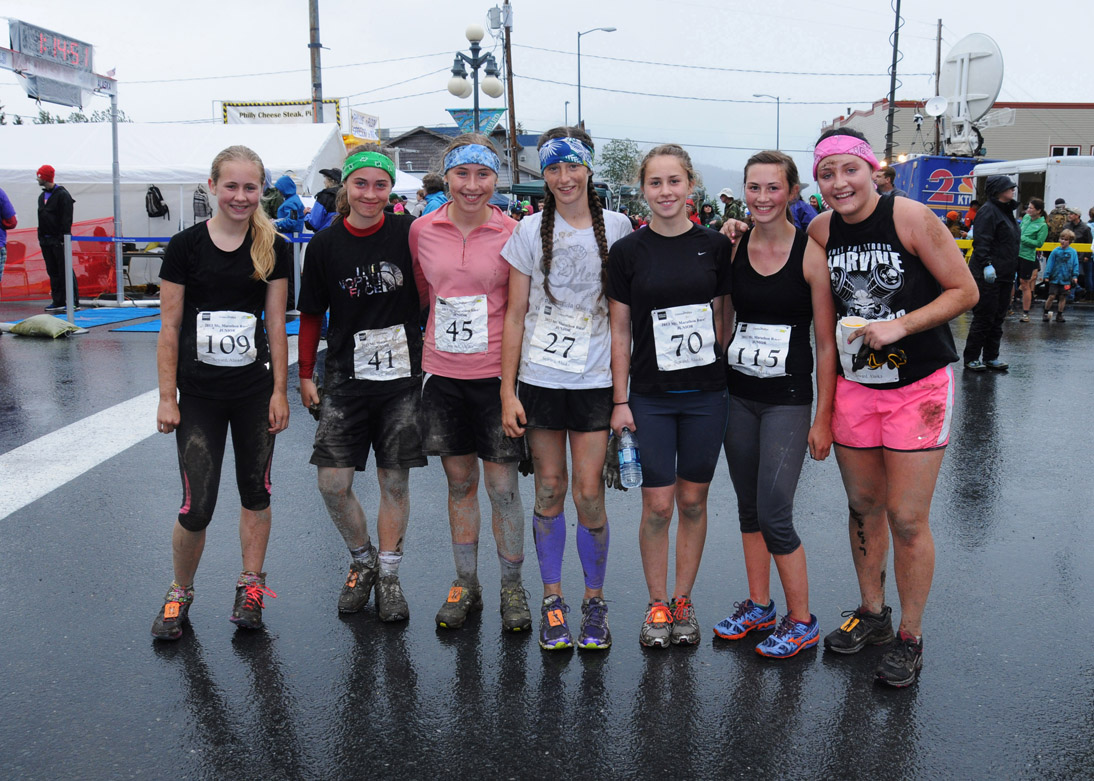 With a layer of mud and a few scrapes and scratches to prove they did it, Homer entrants in Seward’s Mount Marathon junior race catch their breath at the finish line. From left: Izabelle Hagge, Alison McCarron, Brenna McCarron, Megan Pitzman, Lauren Evarts and Brenna Evarts with Katie Costello of Kenai.-Photo by Stephanie Pitzman