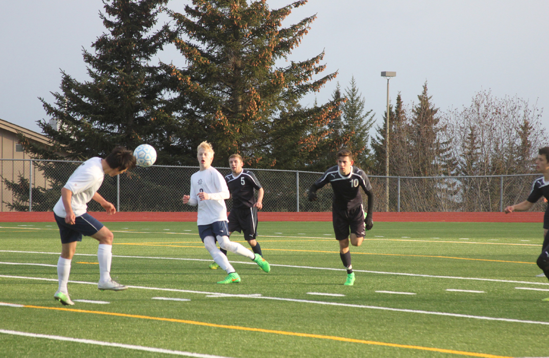 Mariner Senior Ben Westphal, left, heads the ball to freshman Charles Rohr in front of SoHi defense during a home game on Tuesday.-Photo by Shannon Reid