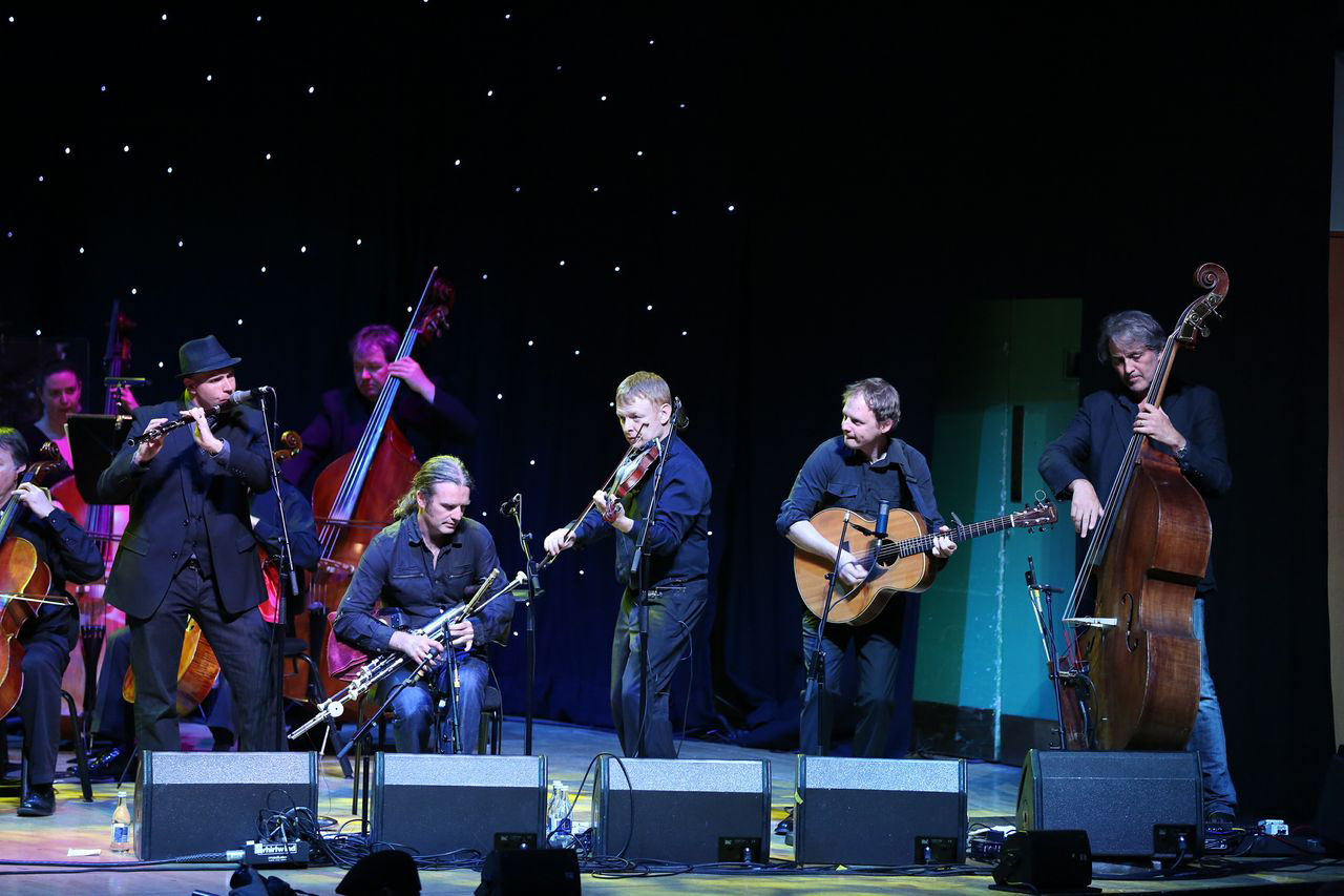 Lúnasa performs with Rté Concert Orchestra. From left to right, front, are Kevin Crawford, flute; Cillian Vallely, uilleann pipes; Seán Smyth, fiddle; Ed Boyd, guitar; and Trevor Hutchinson, bass. -Photo provided