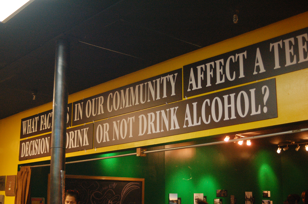 A sign at the PhotoVoice exhibit poses the question artists were asked to explore: “What factors in our community affect a teen’s decision to drink or not drink alcohol?”        -Photo by Michael Armstrong, Homer News
