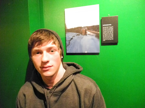 Christopher Bice stands next to his untitled photograph at the First Friday opening of the PhotoVoice exhibit at K-Bay Caffe.  -Photo by Michael Armstrong, Homer News