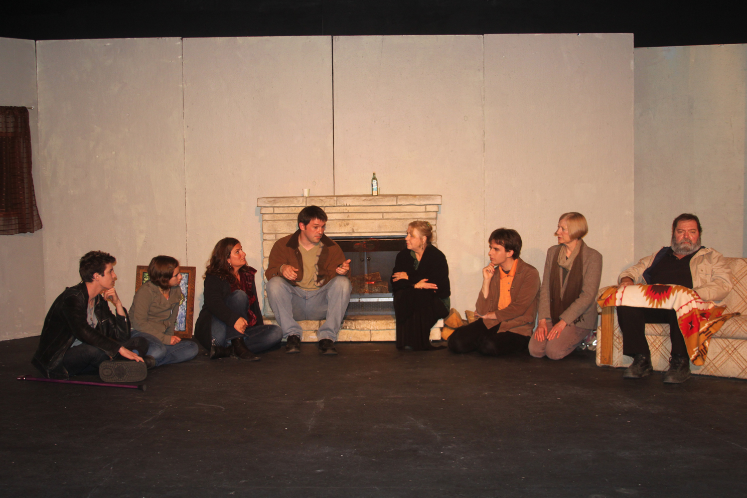 Tom Custer, center, performs a scene from “The Man from Earth” with, from left to right, Rowyn Cunningham, Lindsey Schneider, Amy Reedy, Custer, Linda Ellsworth, Matthew Myer, Nancy Chastain and Peter Norton. “The Man from Earth” ended its run last week. “Remembering Kathy” opens Friday.-Photo by Shannon Reid
