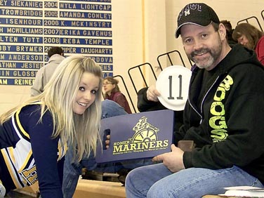 Breeanna Torsen of the Mariner cheer squad finds an easy fundraising target at the Dec. 12 "Meet the Mariners" night, benefiting the Mariner boys basketball team: her dad, Brant "Boog" Torsen. -Photo by McKibben Jackinsky, Homer News