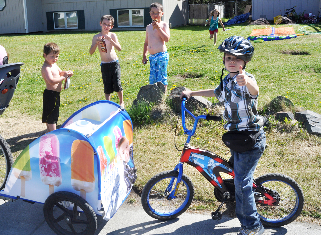 Rohan Lamb, 7, left, gives a thumbs up during his first day of ice cream sales through his mobile business “Ice Cream Rohan” on June 12 in Soldotna.The young entrepreneur can be followed at facebook.com/IceCreamRohan. -Photo by Greg Skinner,  Morris News Service - Alaska