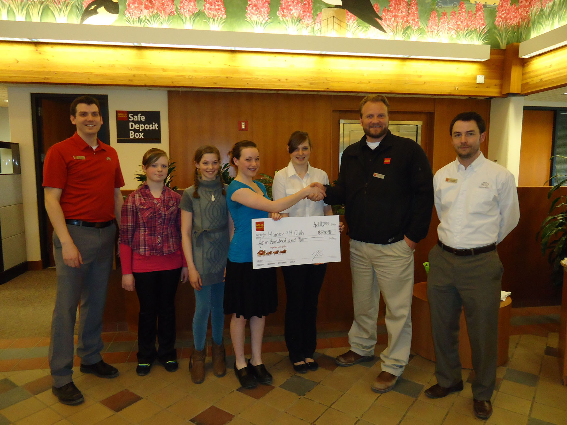 Wells Fargo’s Homer Store Manager Tyler Davis, far left, Business Banking Manager Andy Riddell, second from right, and Kenai Peninsula District Manager Patrick Ryland, far right, present members of the Trailblazer 4-H Club with a check for transportation to the Alaska 4-H Horse Bowl in Fairbanks during an open house April 11 at Wells Fargo. Accepting the check for 4-H are members, from left, Dakota Morris, DeeAnn White, Melanie Mastolier and Melissa Clark. Wells Fargo also presented checks to the Homer Council on the Arts, South Peninsula Haven House and the Kenai Peninsula Food Bank.-Photo Provided