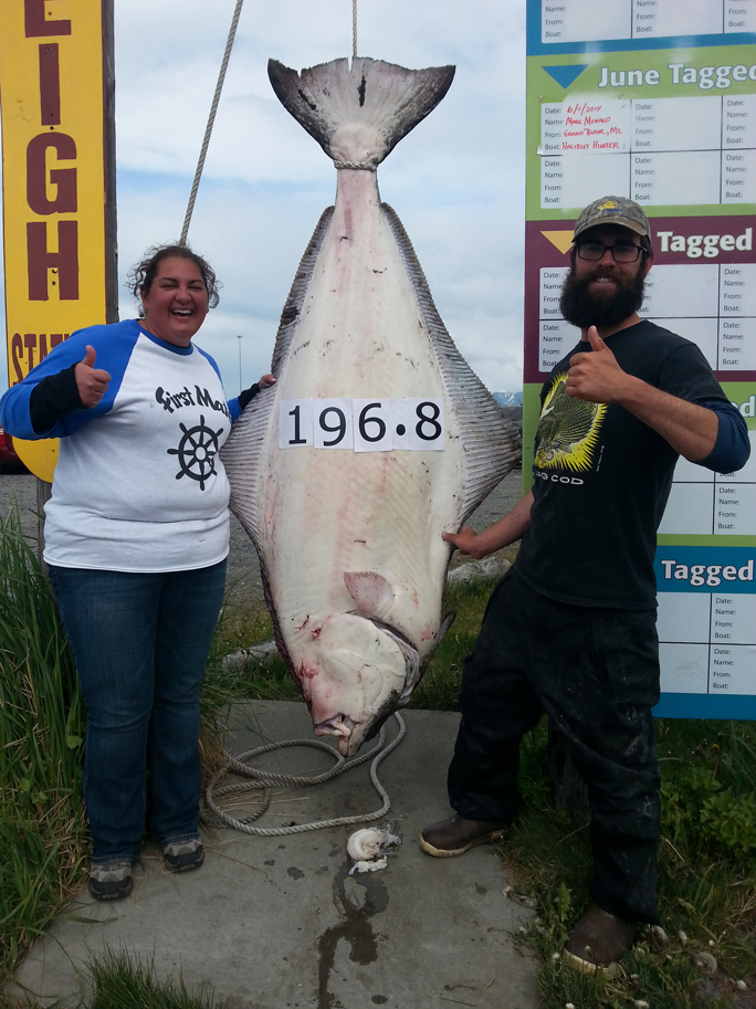 Michigan angler Molly Malthby, left, shows off the halibut she reeled in while fishing with Capt. Ben Martin, right, of North Country Charters.-Photo provided