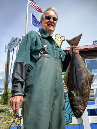 With the tag securely clenched between his teeth, Jim Morgan shows off his catch worth $1,000. -Photo provided