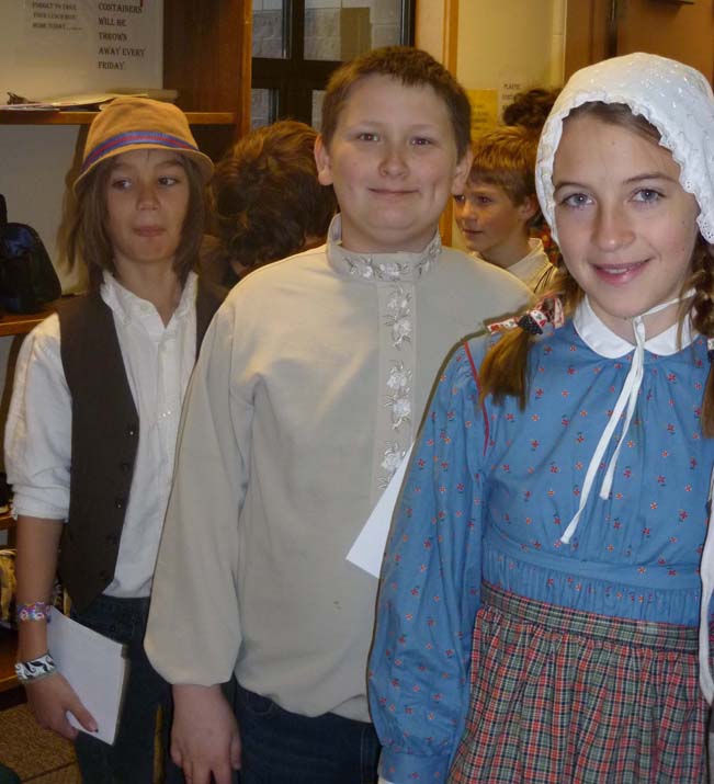 Fireweed Academy students Anthony Melkomukow, in the role of Kondraty Fefelov, a Russian mechanic; Noah Irons, as Wolfgang, a German musician; and Bea Strobel, as Victoria Gurka, a Polish seamstress, wait for a documentation as they role-play being immigrants arriving at Ellis Island during a recent lesson at Fireweed Academy.-Photo provided