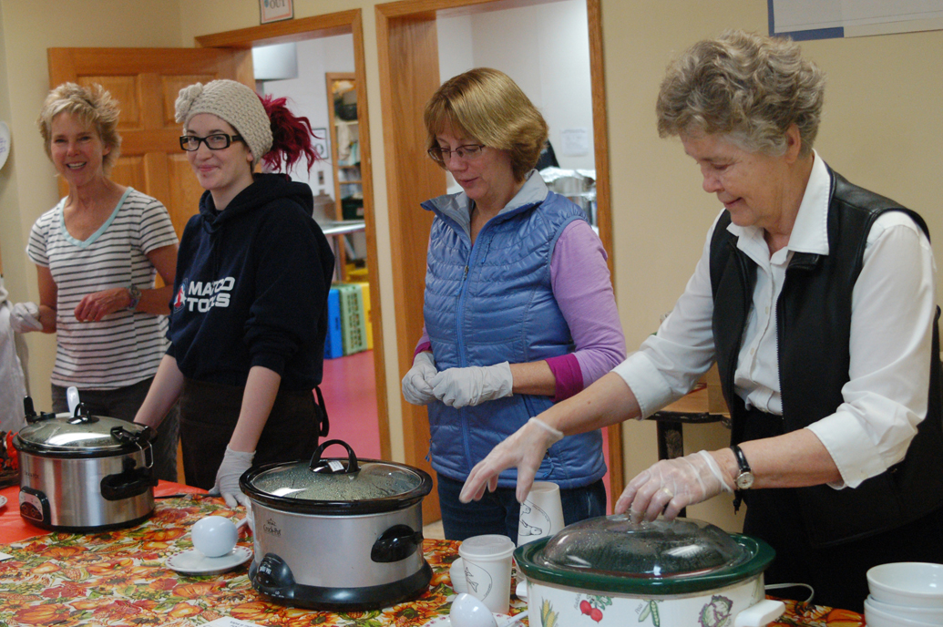 From left to right, Sherry Stead, Julian McFarlin, Annie Wiard and Diana Jeska serve soup at the Empty Bowls Luncheon last Friday at Homer United Methodist Church. Soup was provided by more than 20 local restaurants. A dozen local potters and students from the Homer High School advanced pottery class donated bowls to be sold and filled with soup. The luncheon raised money for the Homer Community Food Pantry.-Photo by Michael Armstrong, Homer News