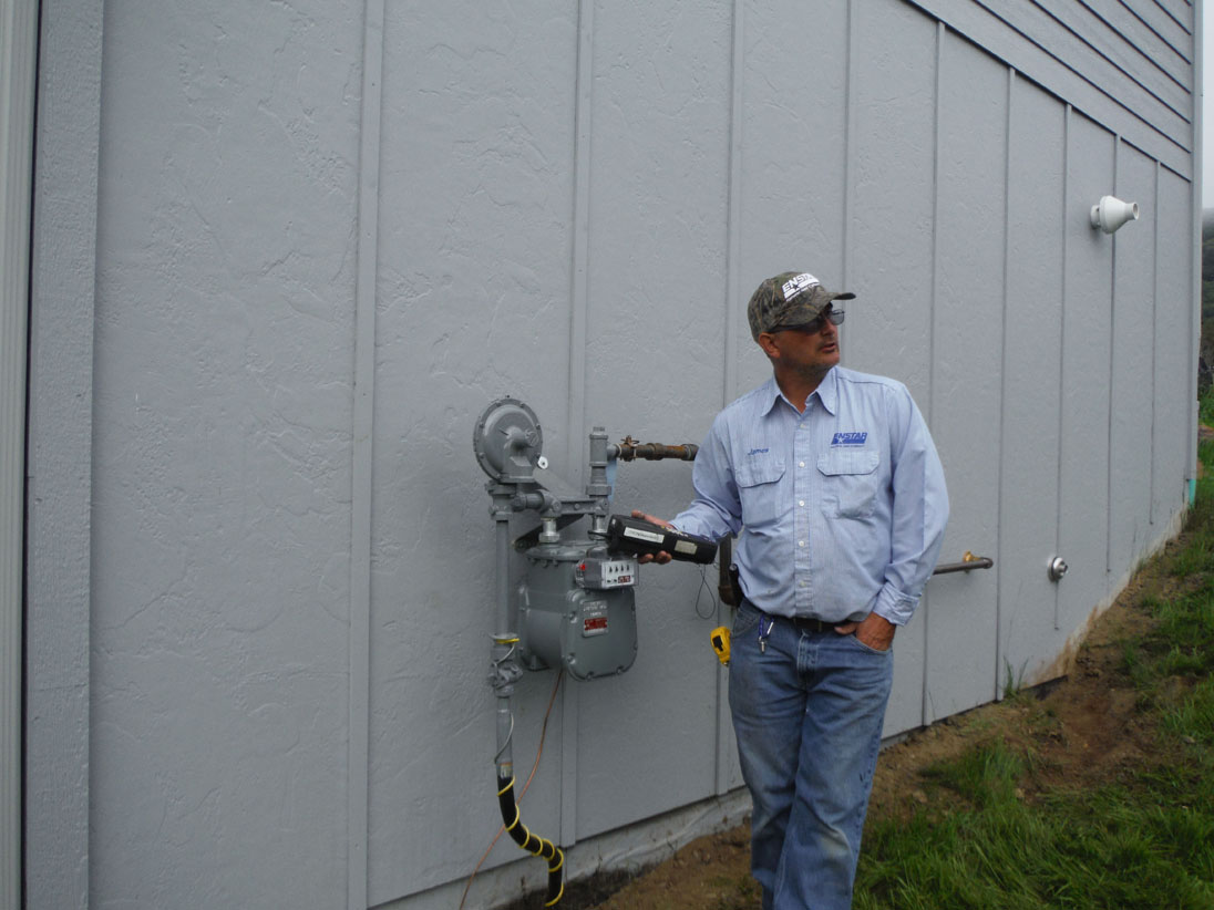 Enstar service technician James Merrow installs the meter on the 119 Fairview Ave. house.-Photo provided
