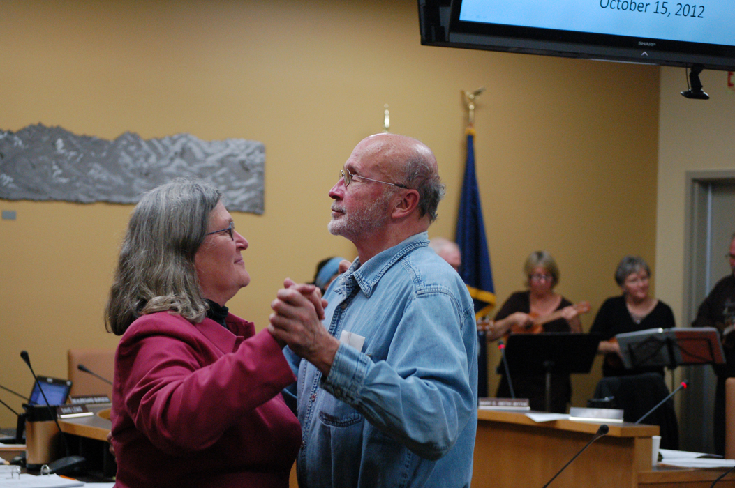 Former Mayor James Hornaday waltzes with council member Francie Roberts at the Homer City Council meeting on Monday night as the Homer Ukulele Group plays. Hornaday laid down his gavel as mayor after swearing-in ceremonies for Mayor Beth Wythe and council members Roberts and Beau Burgess. Roberts was selected mayor pro tempore.-Photo by Michael Armstrong, Homer News