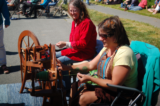 Cindy Argus, left, and Beth Carroll, right, demonstrate spinning fibers at their booth, Namaste Knitting.-Photo by Michael Armstrong, Homer News