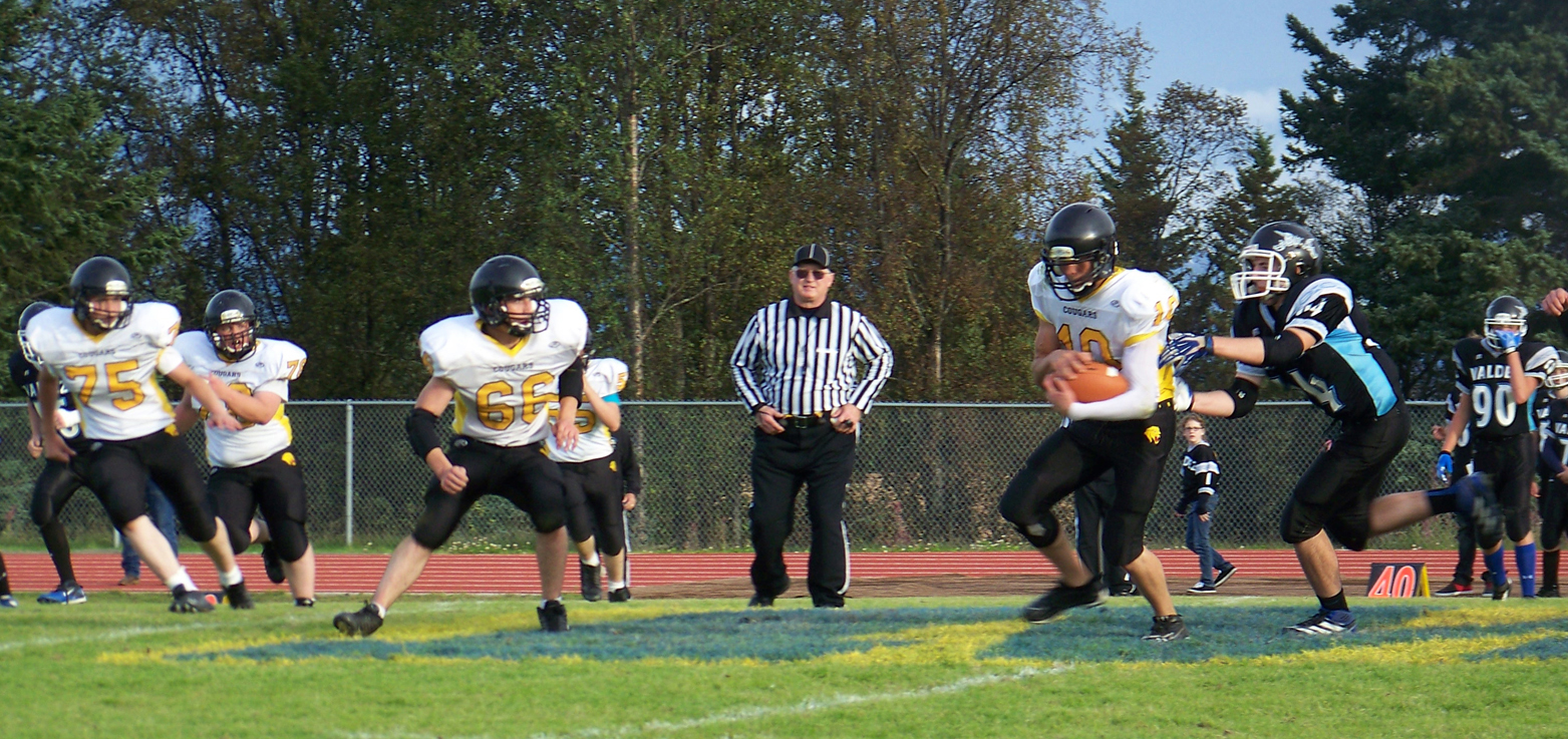 Voznesenka quarterback Avraam Kalugin, 10, stays one step ahead of the Valdez Buccaneers, with teammates Michael Kusnetsov, 75, and Misael Martushev, 66, opening the way for Kalugin’s run for a touchdown.-Photo by McKibben Jackinsky, Homer News