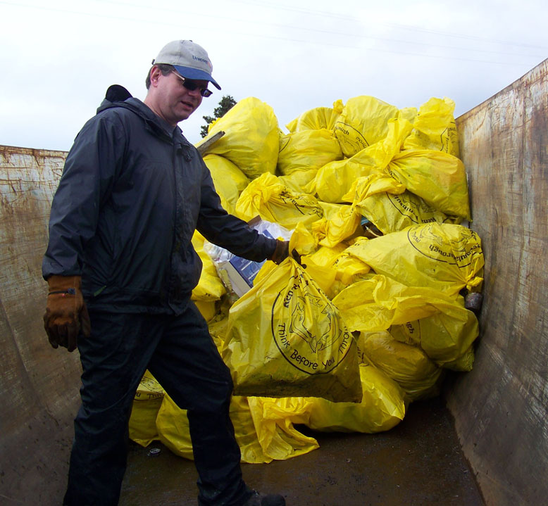Volunteer garbage man Rick Abboud stacks up bags of trash collected on Saturday.-Photo by McKibben Jackinsky, Homer News